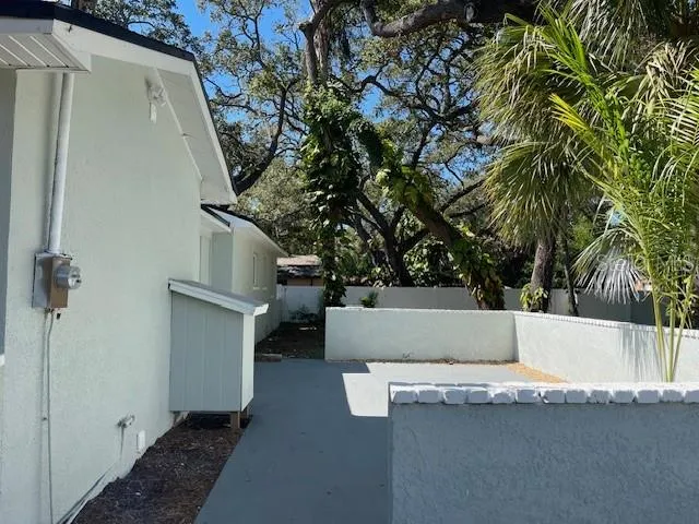a view of outdoor kitchen with granite countertop a couches and iron fence