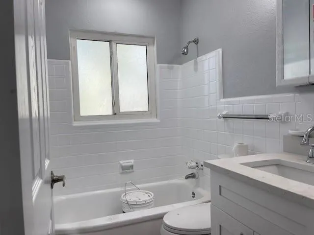 a bathroom with a sink toilet vanity and bathtub