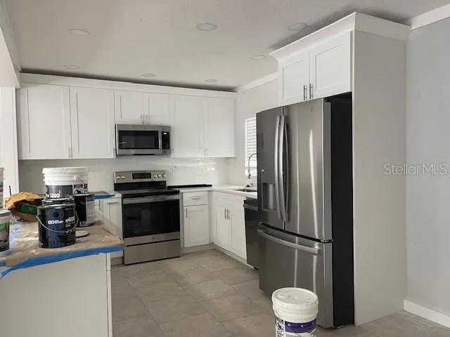 a kitchen with a refrigerator a stove and a sink