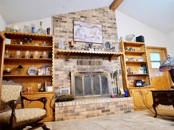 a living room with furniture a flat screen tv and a refrigerator