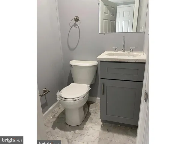 a bathroom with a toilet sink and mirror