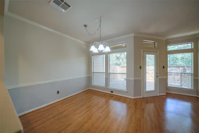 a view of a room with wooden floor and chandelier