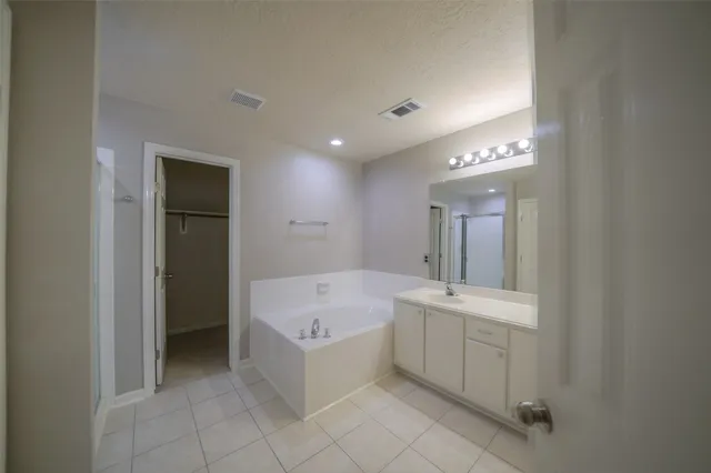 a bathroom with a bathtub sink and mirror