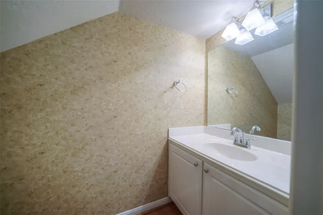 a bathroom with a sink vanity and a mirror