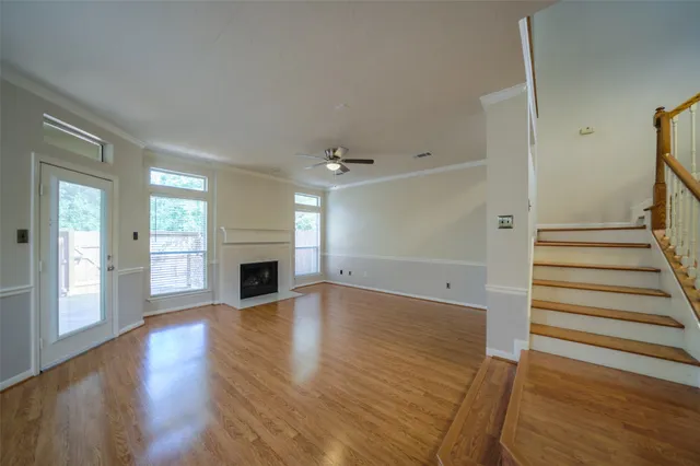 a view of a livingroom with wooden floor and a fireplace