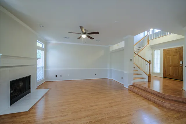 a view of empty room with wooden floor and fireplace