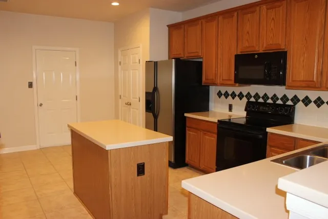 a kitchen with a refrigerator a stove top oven a sink and dishwasher
