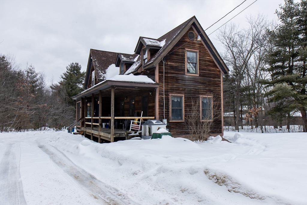 a view of house with yard outdoor seating and covered with snow