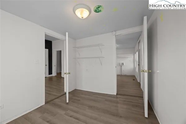 an empty room with wooden floor and entrance