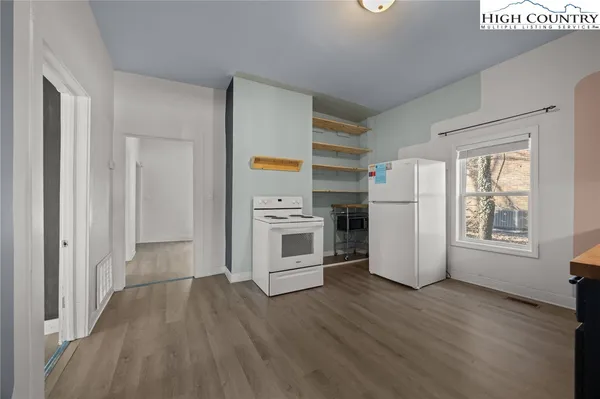 a view of a kitchen with wooden floor and electronic appliances
