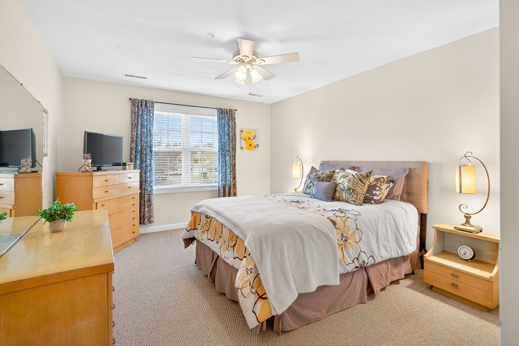 615 Nashua Road, Unit 9 Dracut, MA 01826 - Photo 23 of 38 a bedroom with a bed and a chandelier