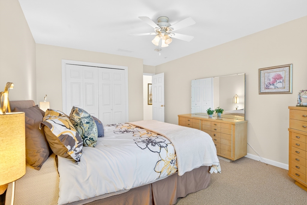 615 Nashua Road, Unit 9 Dracut, MA 01826 - Photo 24 of 38 a bedroom with a bed and a chandelier
