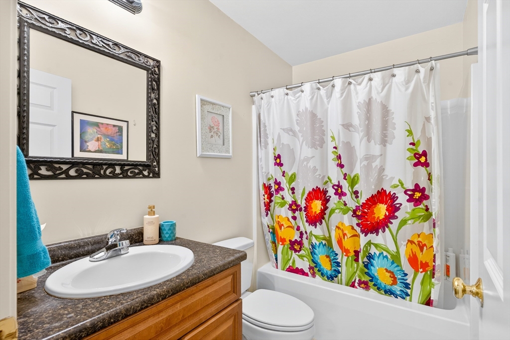 615 Nashua Road, Unit 9 Dracut, MA 01826 - Photo 25 of 38 a bathroom with a sink mirror vanity and toilet