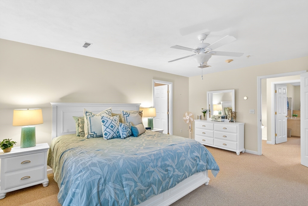 615 Nashua Road, Unit 9 Dracut, MA 01826 - Photo 27 of 38 a spacious bedroom with a large bed and a chandelier