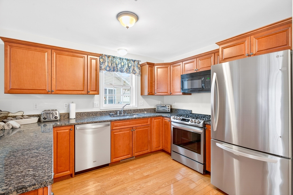 615 Nashua Road, Unit 9 Dracut, MA 01826 - Photo 10 of 38 a kitchen with stainless steel appliances granite countertop a stove a sink dishwasher a refrigerator and cabinets with wooden floor