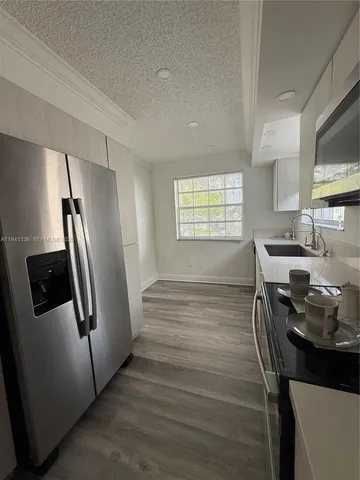 a kitchen with stainless steel appliances granite countertop a refrigerator a stove a sink and a microwave