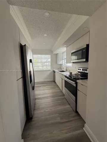 a kitchen with stainless steel appliances a refrigerator sink and microwave