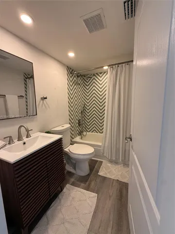 a bathroom with a sink a toilet a mirror and shower