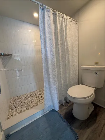 a bathroom with a toilet and a shower
