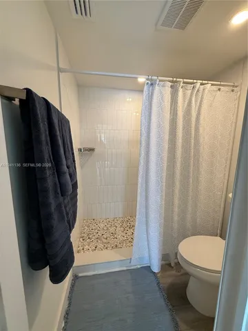 a bathroom with a toilet and a shower
