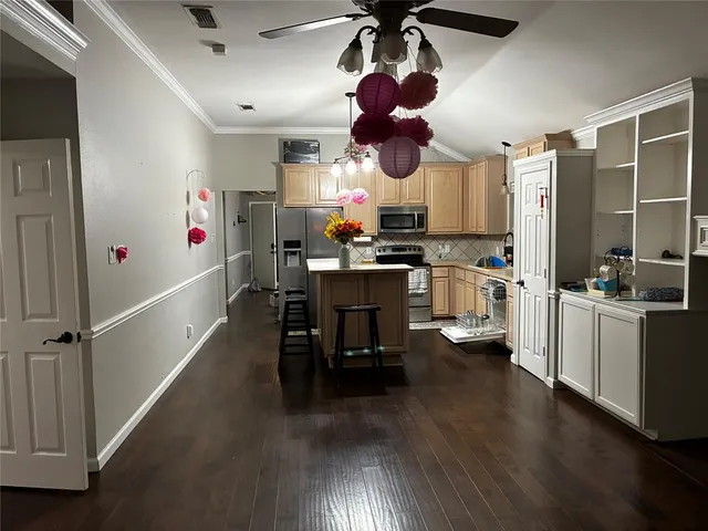 a kitchen with stainless steel appliances wooden floor dining table and chairs