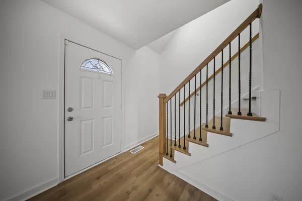 a view of staircase with railing and white walls