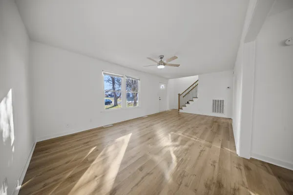 a view of empty room with wooden floor