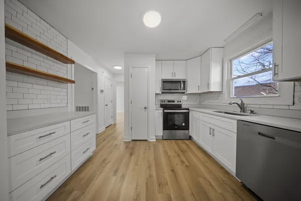 a kitchen with stainless steel appliances a refrigerator sink and cabinets