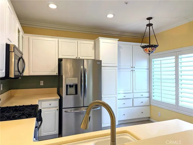 a kitchen with stainless steel appliances granite countertop a refrigerator and a sink