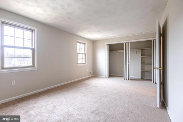 an empty room with windows and closet