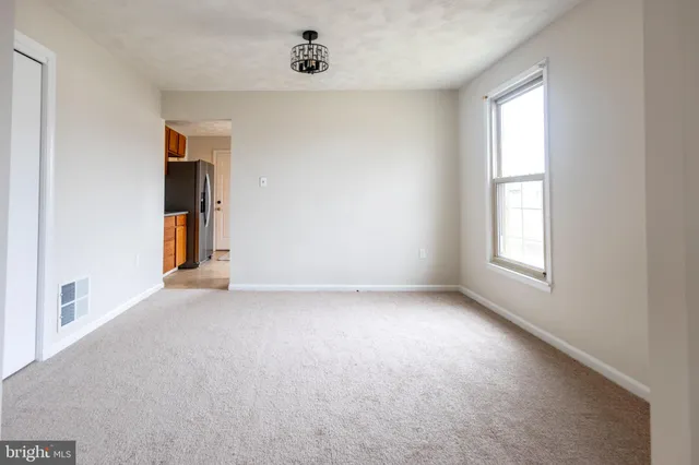 an empty room with windows and cabinet