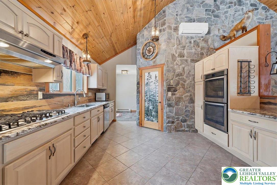 134 Split Rock Road Newfoundland, PA 18445 - Photo 26 of 84 a large kitchen with stainless steel appliances granite countertop a stove and cabinets