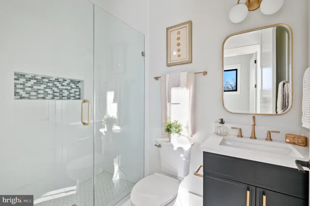 a bathroom with a granite countertop sink mirror a toilet and shower