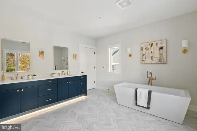 a spacious bathroom with a double vanity sink mirror and bathtub