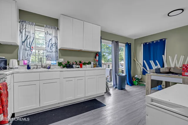 a kitchen with a refrigerator and white cabinets