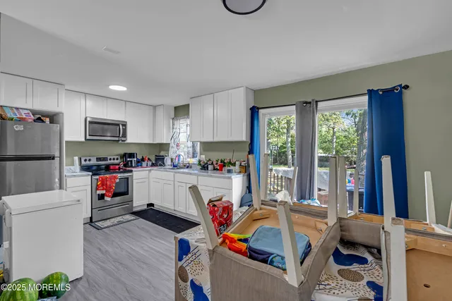 a living room with furniture a flat screen tv and a refrigerator