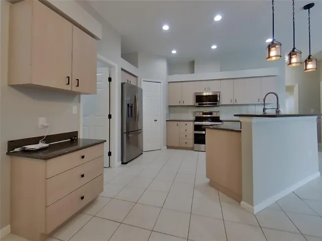 a kitchen with stainless steel appliances granite countertop a refrigerator and a stove top oven