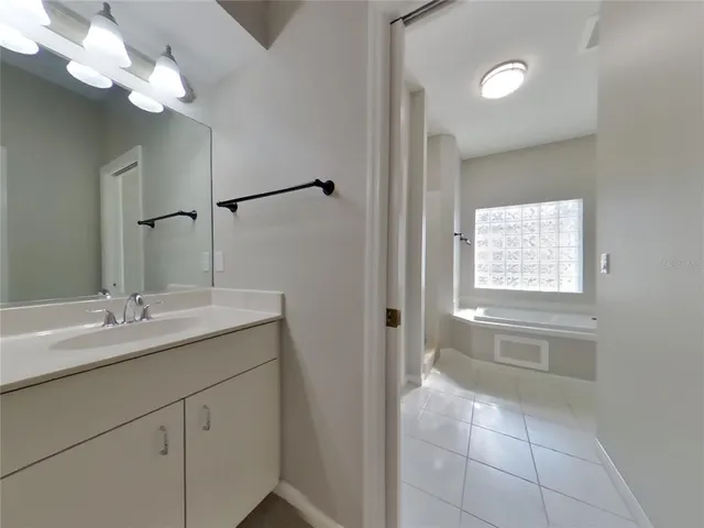 a bathroom with a granite countertop sink a toilet and a mirror