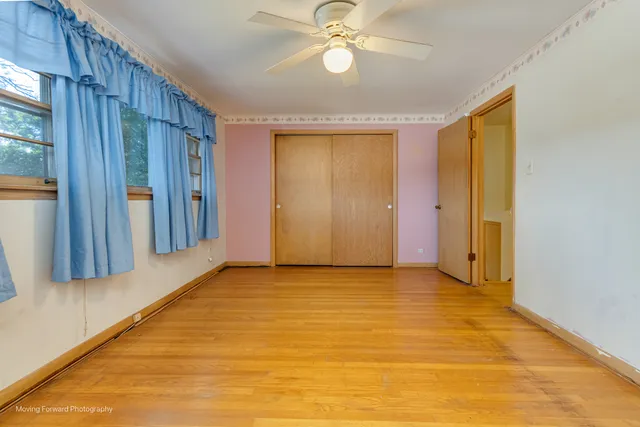 a view of an empty room with chandelier fan and fire place