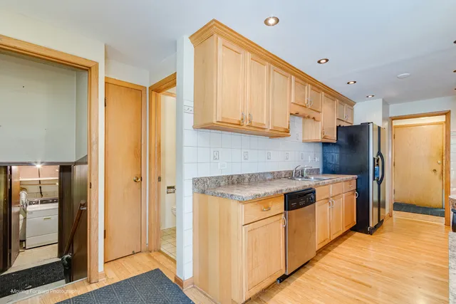 a kitchen with stainless steel appliances granite countertop a refrigerator a sink and a stove