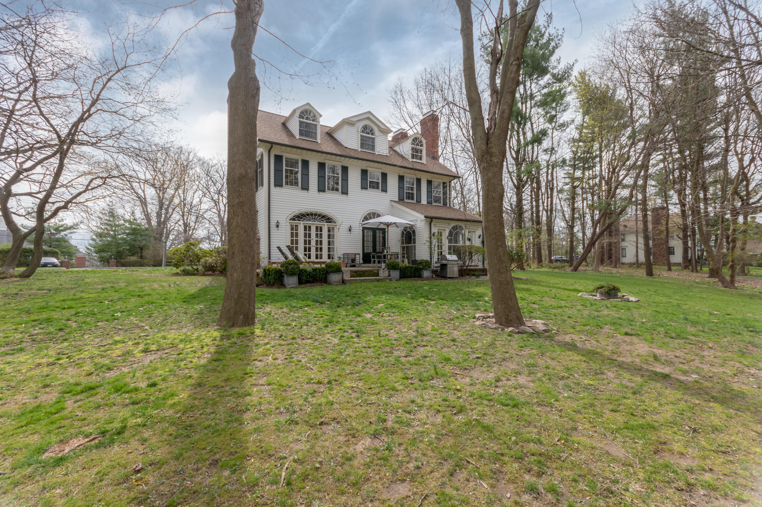 106 Long Neck Point Road Darien, CT 06820 - Photo 41 of 48 a view of a white house with a yard and plants