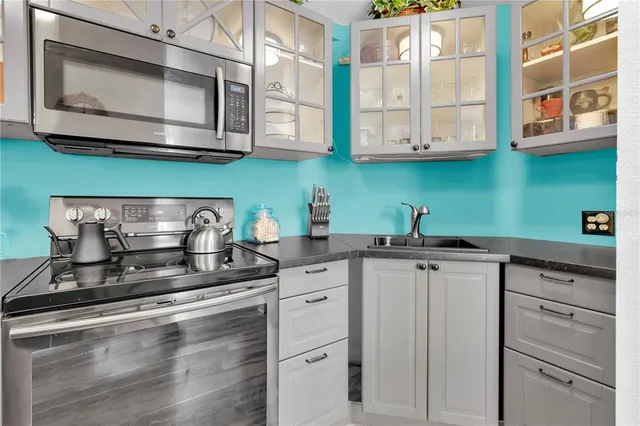 a kitchen with stainless steel appliances granite countertop white cabinets and a stove top oven with a dishwasher