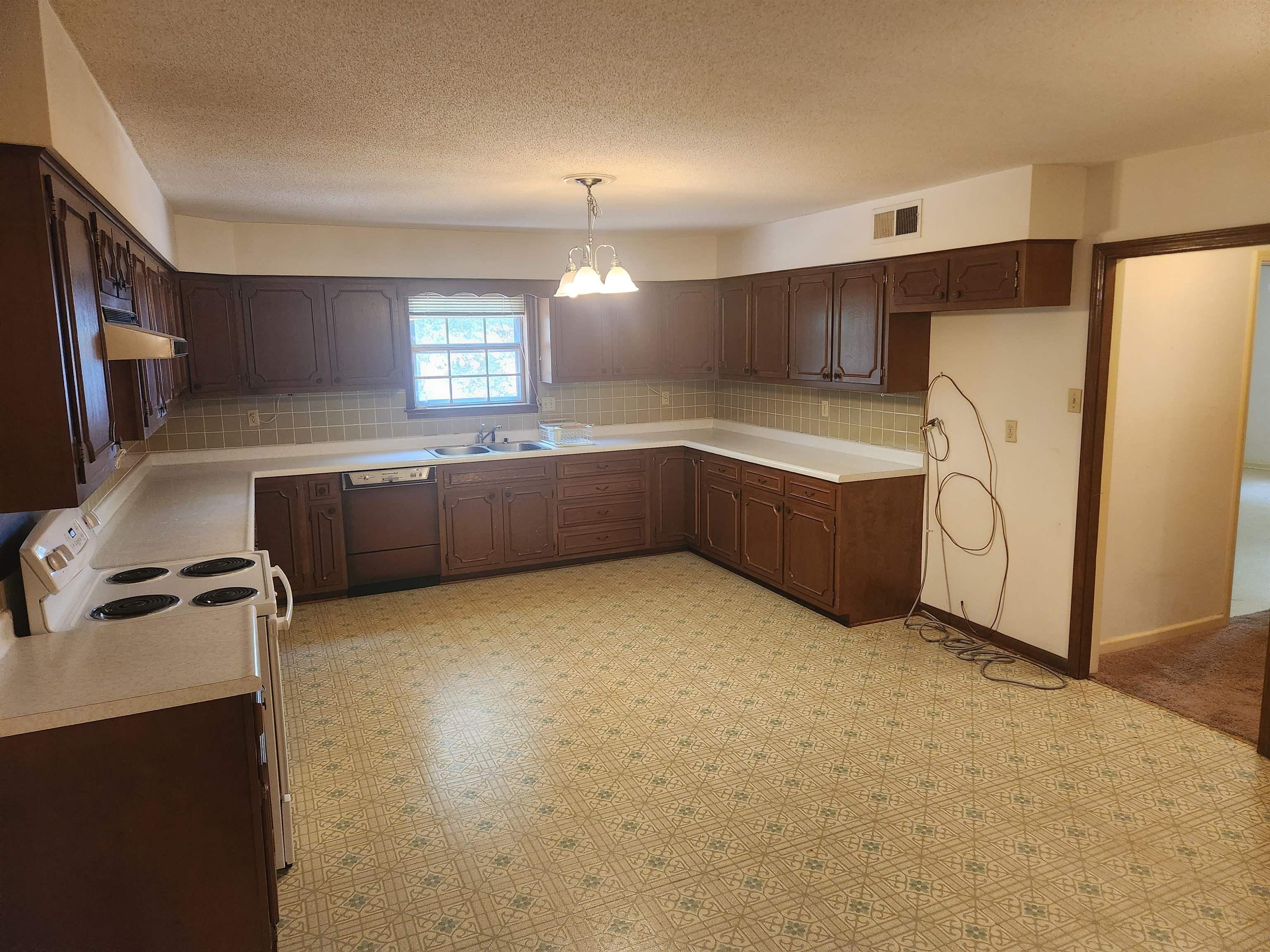 7505 Dexter Road Cordova, TN 38016 - Photo 8 of 27 Kitchen with an inviting chandelier, custom range hood, tasteful backsplash, dishwasher, and pendant lighting