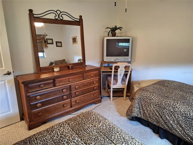 a bedroom with a bed and a mirror on dresser