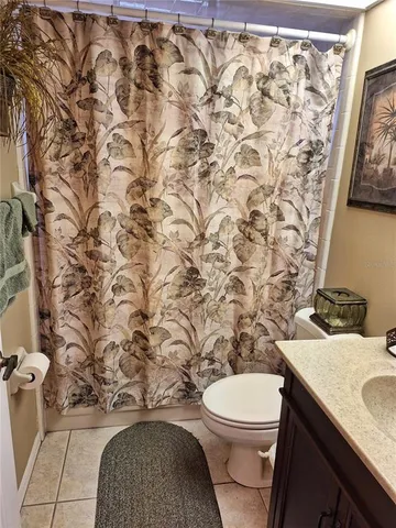 a bathroom with a granite countertop toilet and a sink