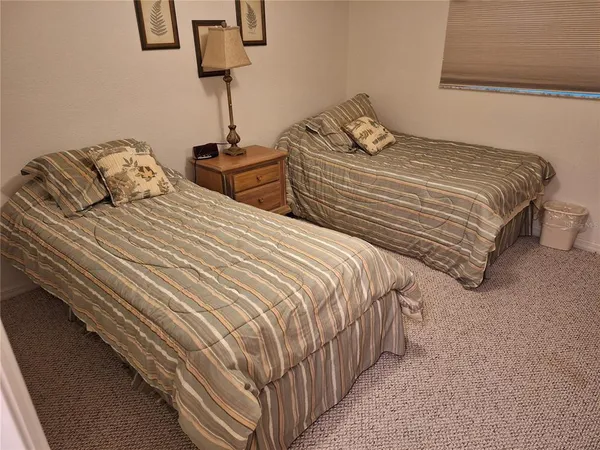 a bedroom with two beds and a lamp