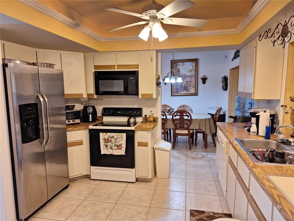 2223 Tinker Street Port Charlotte, FL 33948 - Photo 5 of 23 a kitchen with stainless steel appliances granite countertop a refrigerator a stove top oven a sink and dishwasher