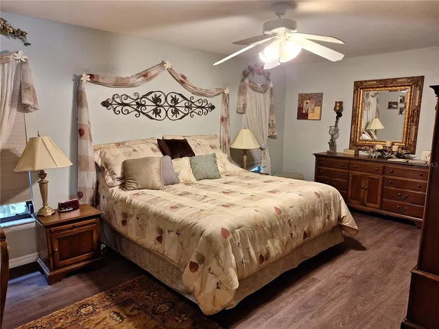 a bedroom with a bed and dresser with chair