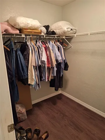 a view of walk in closet with clothes and shoes