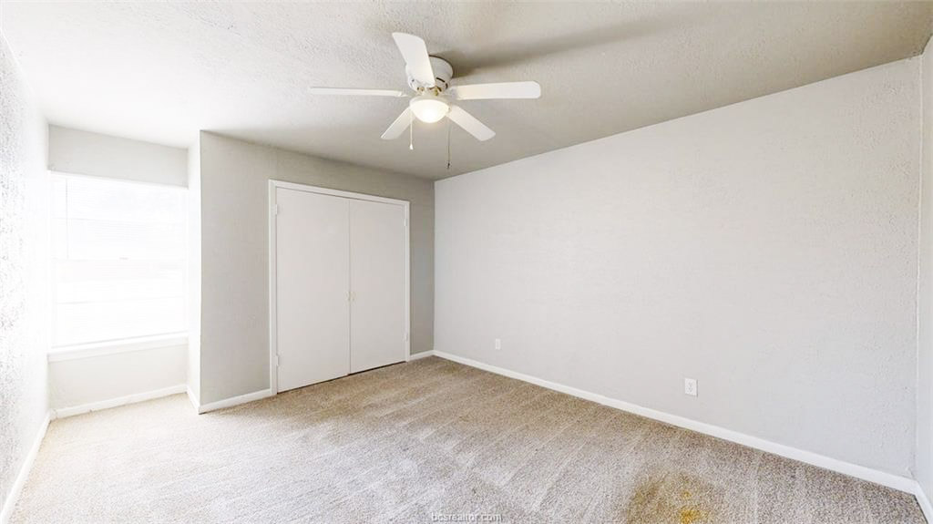 3800 East 29th Street, Unit 18 Bryan, TX 77802 - Photo 11 of 22 an empty room with a ceiling fan and wooden floor